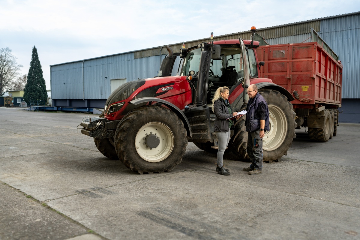 Katrin Beberhold auf ihrem Hof vor dem Traktor im Gespräch mit einer männlichen Person Katrin Beberhold auf ihrem Hof vor dem Traktor im Gespräch mit einer männlichen Person