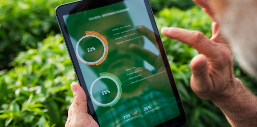 Mann steht im Feld und schaut sich Auswertungen auf einem Tablet an